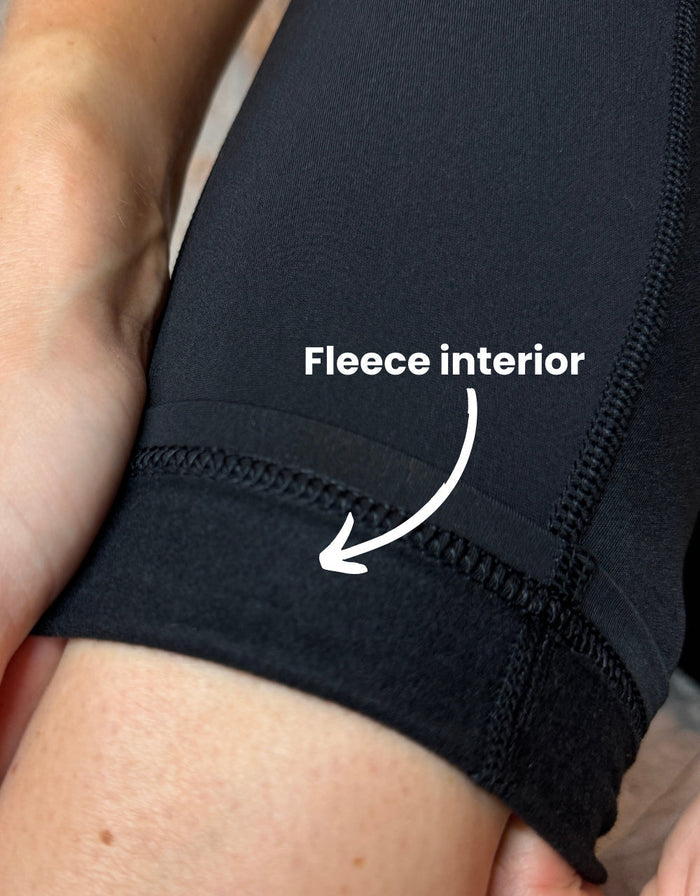 Close-up of black gym leggings showing soft fleece-lined interior for warmth and comfort