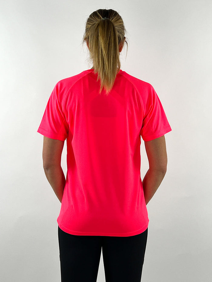 Woman wearing electric pink active t-shirt from the back against a plain background