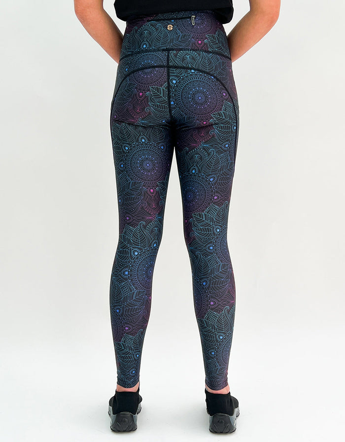 Woman wearing Midnight Mandala Activewear leggings with subtle mandala pattern and pockets, back view