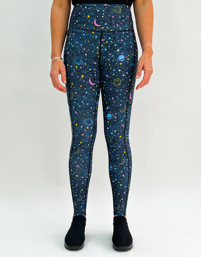 Women wearing Out Of This World activewear leggings with intergalactic star and planet patterns and pockets