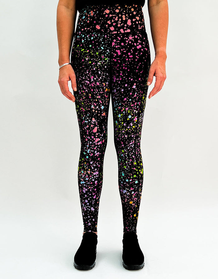 Front view of pink galaxy activewear leggings with colorful splatter pattern and pockets worn by person