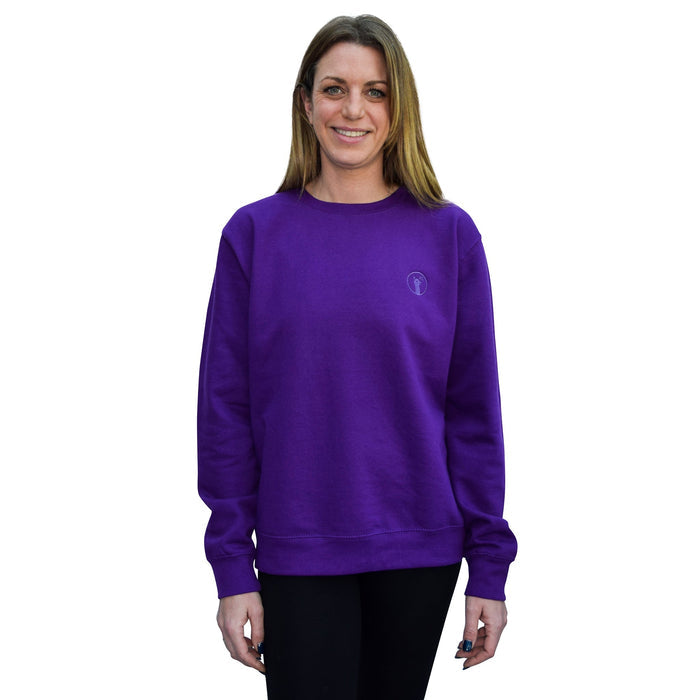 Woman wearing a purple sweatshirt with a relaxed fit and ribbed cuffs and hem.