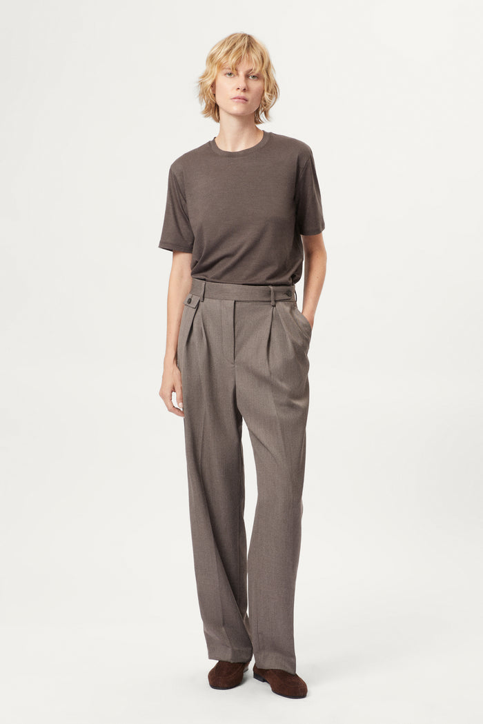 Person wearing a brown active wool t-shirt and pants on a white background