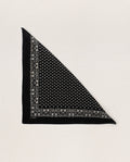 Displayed on a plain light background, THE GREAT. SP24 D2's product, The Bandana in small, features an ultra-soft tri-folded fabric made from 100% cotton in an almost black shade with intricate white floral and star patterns adorning the edges and center.