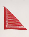 Introducing The Bandana. -- Small -- Bright Red by THE GREAT. CARRYOVER—crafted from ultra-soft cotton for lasting comfort and durability. This vintage-inspired bandana is folded into a triangle and showcases a bright red color with a white floral and paisley border pattern, along with delicate white designs at the center. Washable for easy care, it is photographed against a plain off-white background.