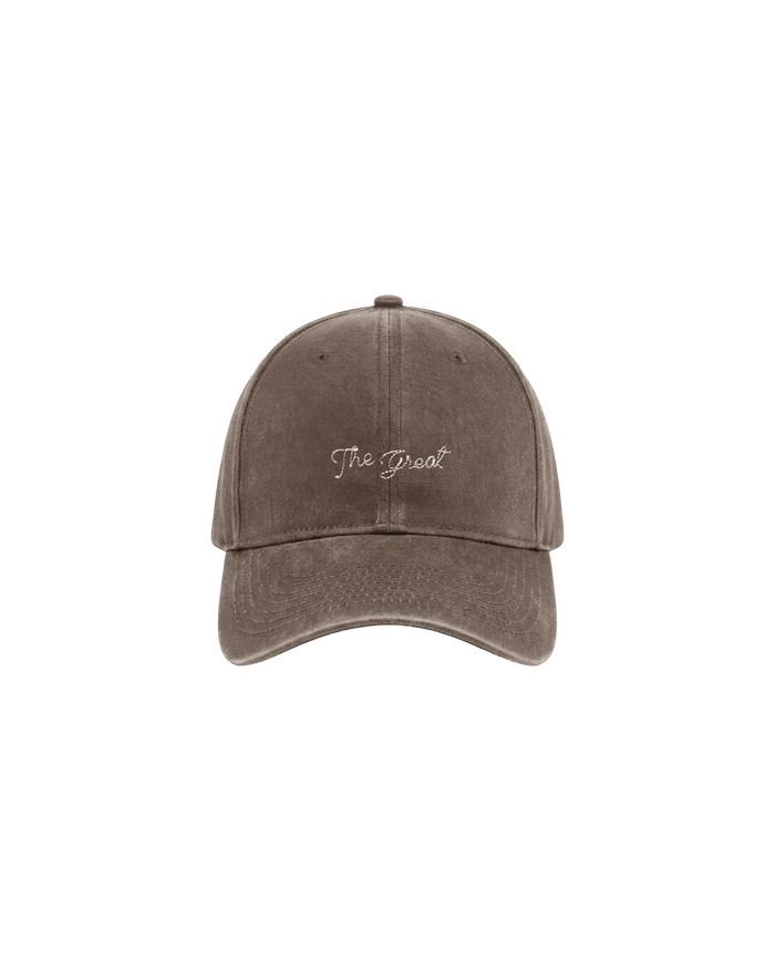 THE GREAT. F26 D1 The Baseball Hat -- Chocolate, featuring “The Great” embroidered in white vintage chainstitch across the front, displayed against a plain white background. Includes an adjustable back for a comfortable fit.