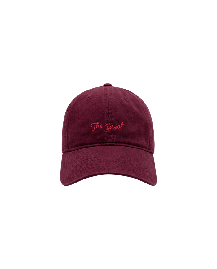 A maroon The Baseball Hat by THE GREAT. F26 D1, featuring vintage “The Great” embroidery in red on the front and an adjustable back, displayed against a plain light gray background.