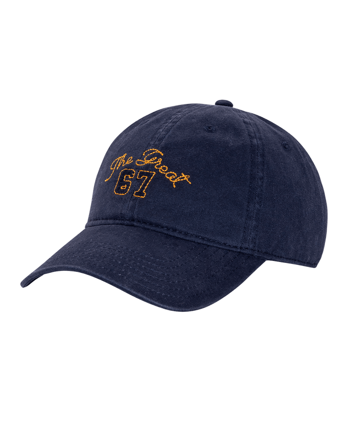 The Baseball Hat by THE GREAT. PF26 in navy features gold embroidered text "The Great 67" on the front.