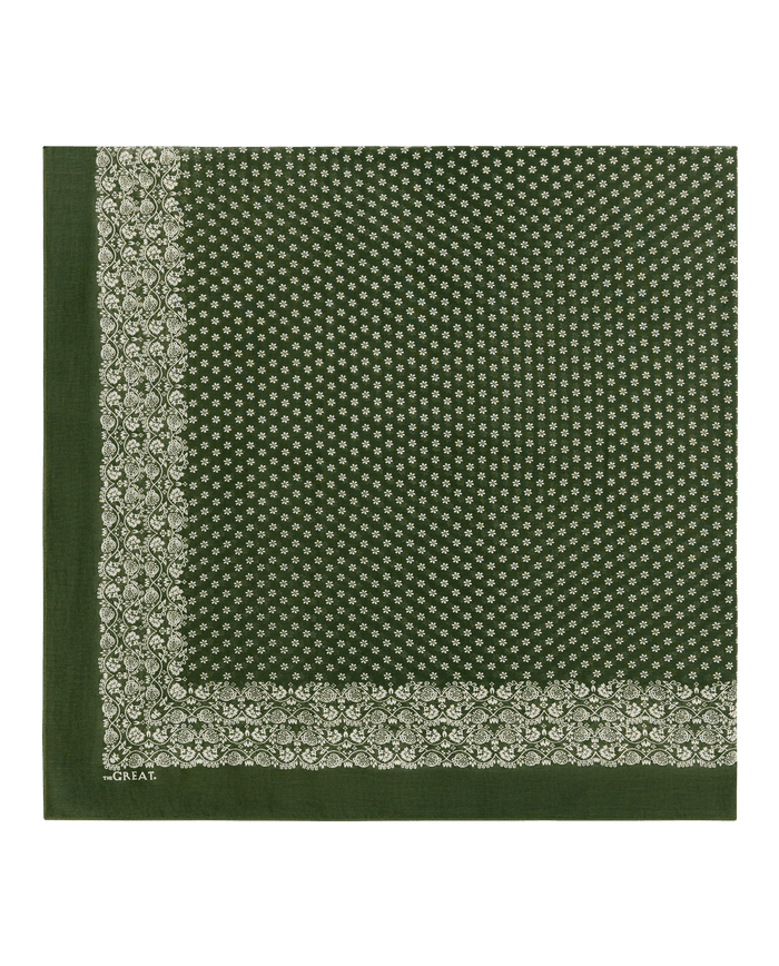 Sure! Here's a rewritten version using your product data: The Big Bandana in Army by THE GREAT. features an army green cotton fabric with a white floral border and small white dot pattern in the center; this oversized bandana is shown laid flat against a plain background.
