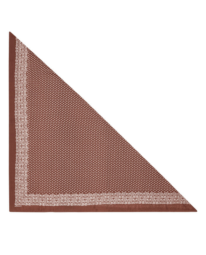 Introducing THE GREAT. F26 BIG BANDANA — The Big Bandana in Chocolate: a brown, triangular vintage-style accessory featuring a delicate small geometric dot pattern at the center and lighter floral borders along the two shorter edges, shown against a white background.