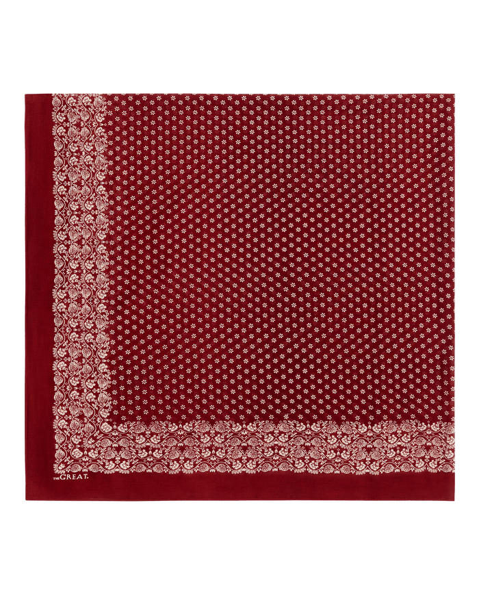 Introducing THE GREAT. F26 BIG BANDANA—The Big Bandana in a rich maroon shade, designed with a crisp white paisley border and delicate white floral motifs across the center. This classic cotton accessory elevates any outfit, whether worn as a timeless scarf or a unique maroon shawl accent.