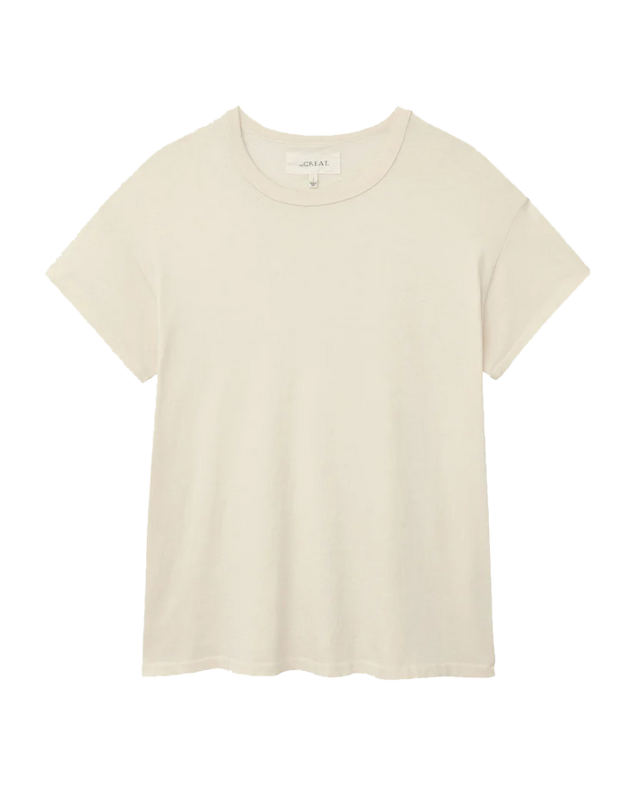 A plain washed white short-sleeve T-shirt with a crew neckline, made from 100% cotton, displayed against a white background. It's called The Boxy Crew by THE GREAT. CORE KNITS.