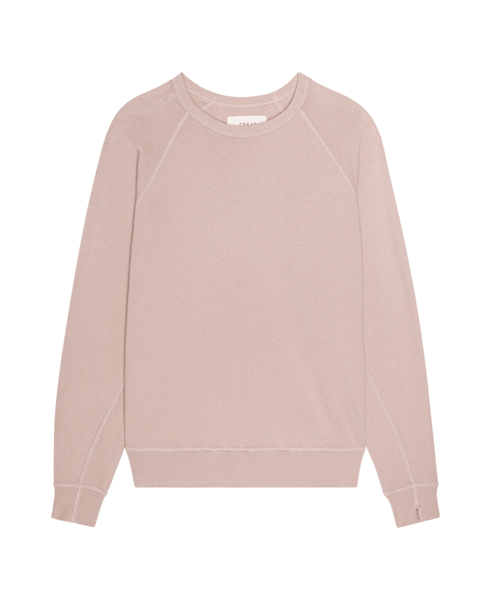 The College Sweatshirt in Ballet Pink by THE GREAT. F26 SEASONAL CORE is a light pink, oversized crewneck with long raglan sleeves and a plain design, handcrafted in Los Angeles and shown laid flat on a white background.