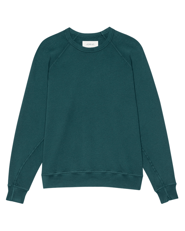 A handcrafted THE GREAT. F26 SEASONAL CORE “The College Sweatshirt” in Dark Slate, featuring long sleeves, visible seam details, and a small white label at the back of the neck.