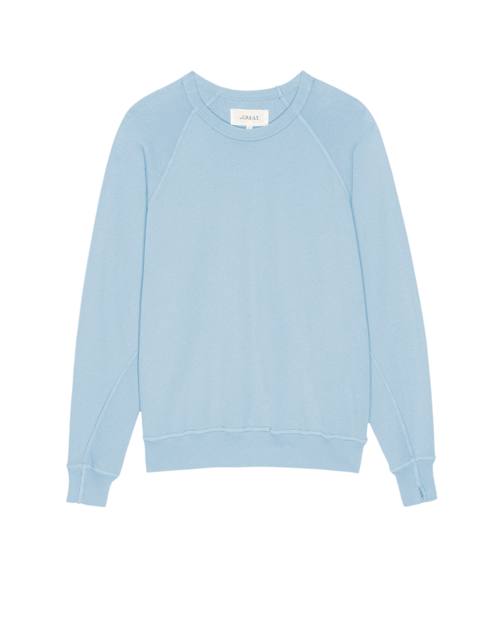 The College Sweatshirt in Solid Vista Blue by THE GREAT. SU25 SEASONAL KNITS, featuring long sleeves with ribbed cuffs and hem, is laid flat on a white background.