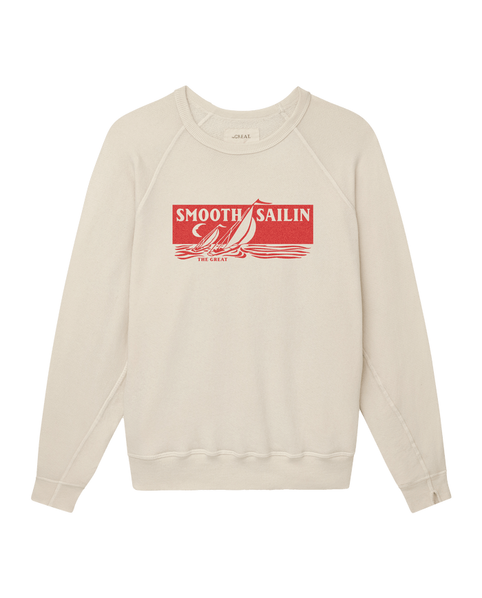 The College Sweatshirt W/ Smooth Sailin Graphic by THE GREAT. SU26 in washed white features a red sailboat with "SMOOTH SAILIN’" and "THE GREAT" text on the front.