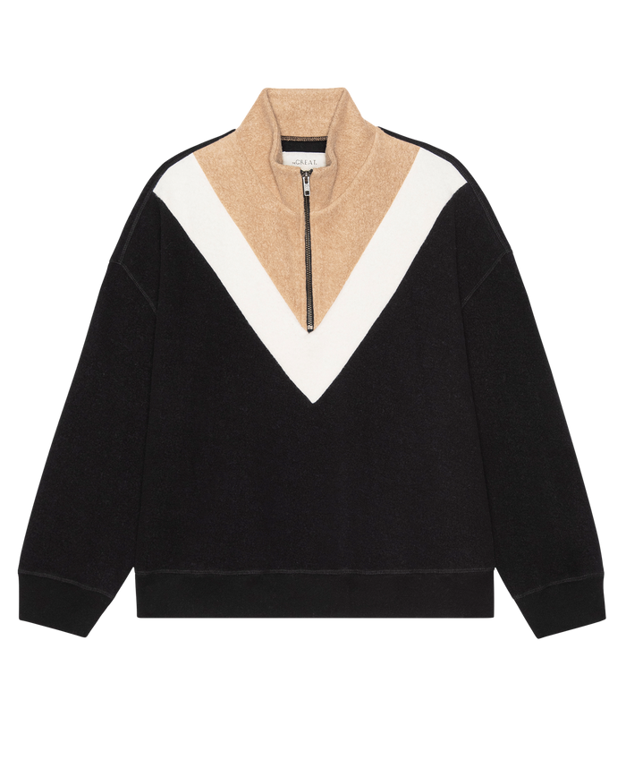 The Colorblock Plush Chalet Sweatshirt by THE GREAT. H25 TEDDY FLEECE features a black body, tan collar and upper, white chevron detail, cozy fleece feel, long sleeves, and a half-zip front closure. Color: Almost Black.