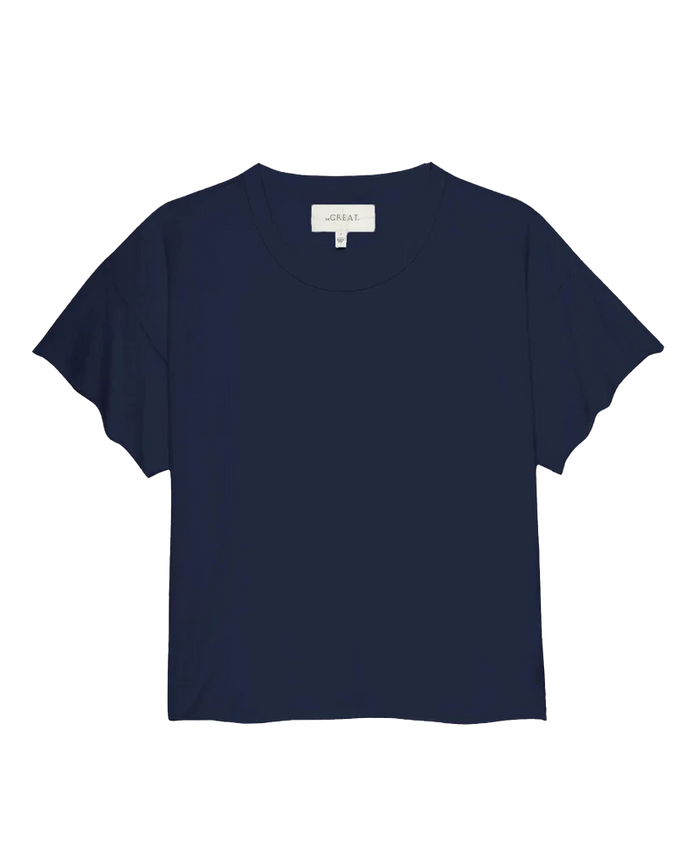 The Crop Tee in True Navy from THE GREAT. FALL 23 KNITS, featuring short sleeves and a super soft cotton fabric with a round neckline, showcased against a white background. Ideal for pairing with high-rise jeans to achieve a chic, casual look.