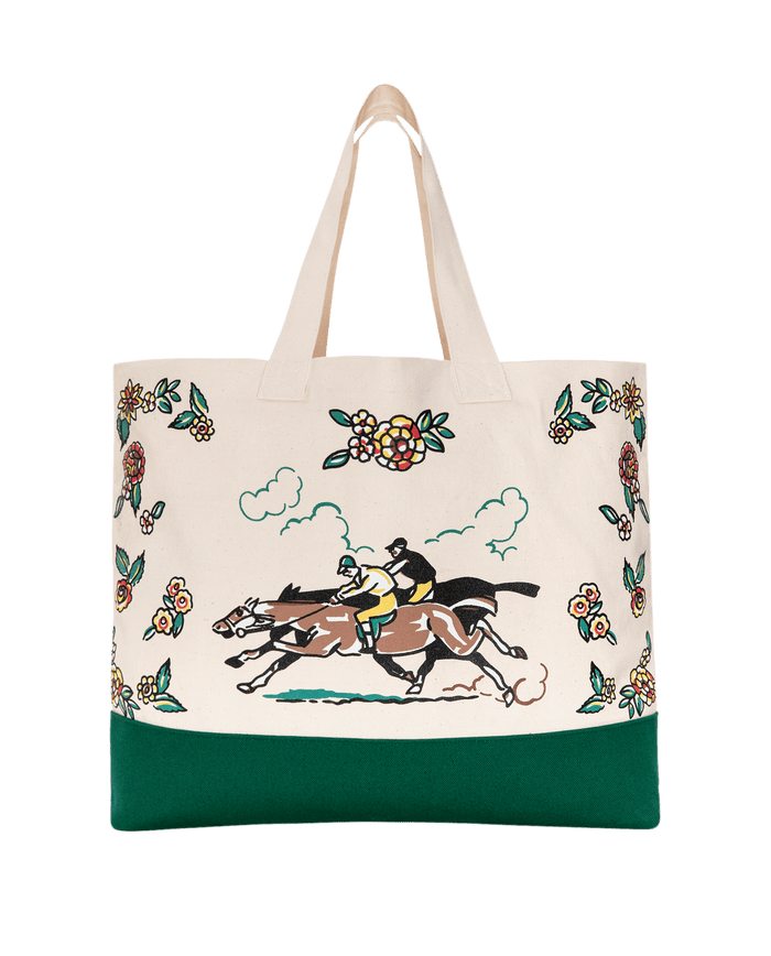 The Derby Tote in cream by THE GREAT. PF26 features green trim and a vibrant design with two jockeys racing amid floral motifs—a stylish, unique accessory for any occasion.