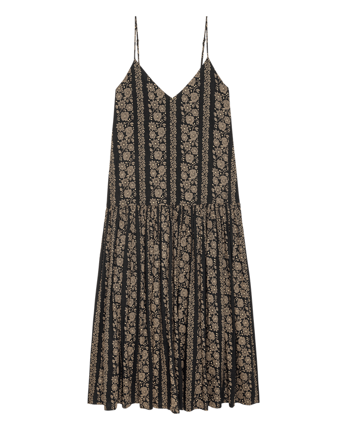 The Drop Waist Dress by THE GREAT. SU26 features a sleeveless black design with thin straps, a V-neckline, and cream token floral print, finished with a gathered, flowy drop waist skirt.