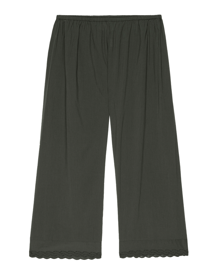 The Eyelet Easy Sleep Pant by THE GREAT. PS25 SLEEP offers a relaxed yet elegant look with its black elastic waistband, soft cotton voile fabric, wide legs, and Victorian-inspired eyelet lace trim at the hem.