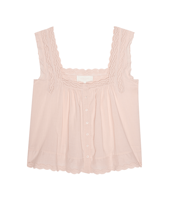 The Eyelet Tank in Washed Rose by THE GREAT. F26 SLEEP is a light pink women’s sleeveless top with a square neckline, scalloped eyelet lace trim, front buttons, and a loose fit, shown against a plain white background.