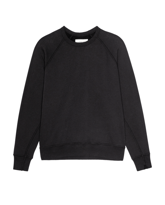 The Fleece College Sweatshirt in Solid -- Almost Black by THE GREAT., crafted from soft French Terry with long sleeves, ribbed cuffs, and a ribbed hem, is laid flat on a white background.