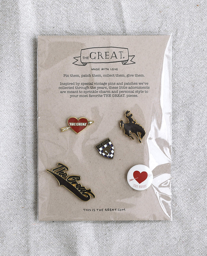 The Great Five Pack Enamel Pins, offered by THE GREAT. HOL 22 ACCESSORIES, is a set of five collegiate-inspired enamel pins in assorted designs, elegantly arranged on a sealed card. The card features the text "THE GREAT. Made with Love," along with a vibrant description of the pin collection in bold colors.