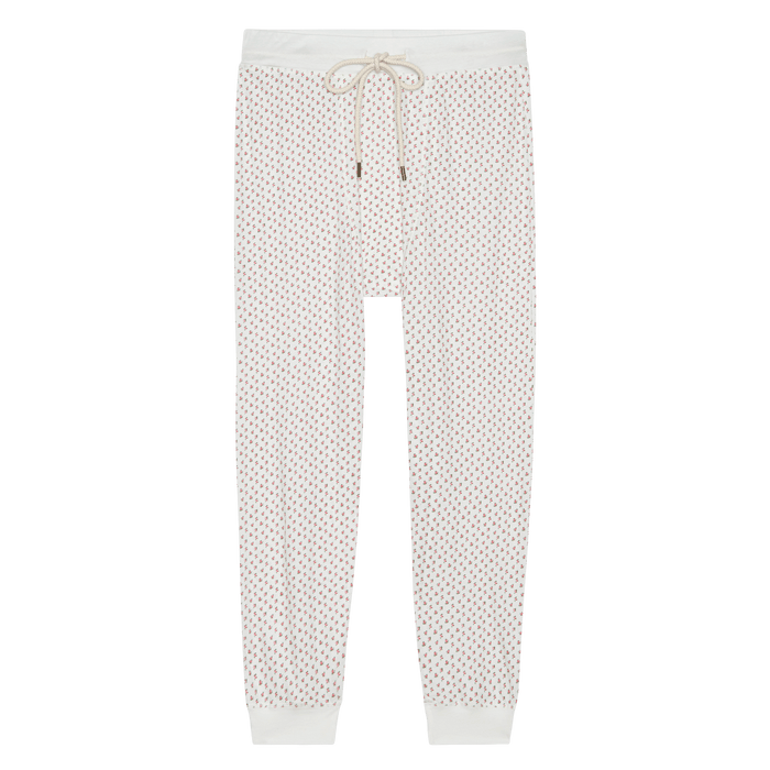 THE GREAT. PS26 SLEEP's The Jersey Long John – Calico Rose: white cotton jersey pajama pants with a red and blue geometric pattern, drawstring waistband, and cuffs. Cozy and stylish as a base layer or sleepwear.