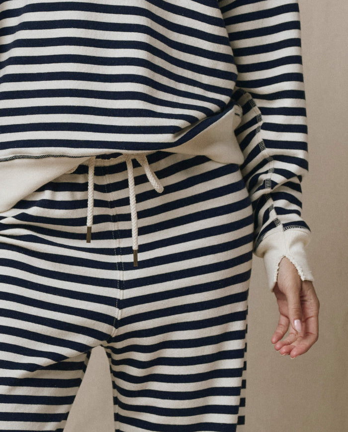 Wearing THE GREAT.'s The Lap Sweatpant in Navy Sailor Stripe, a handcrafted Los Angeles quality set with wide cropped legs, cream and navy stripes, and drawstrings tied at the waist from the SP26 Seasonal Core collection.