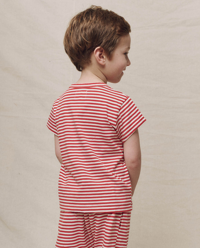 A child wearing The Little Boxy Crew in Sun Cherry Stripe faces sideways against a plain background.