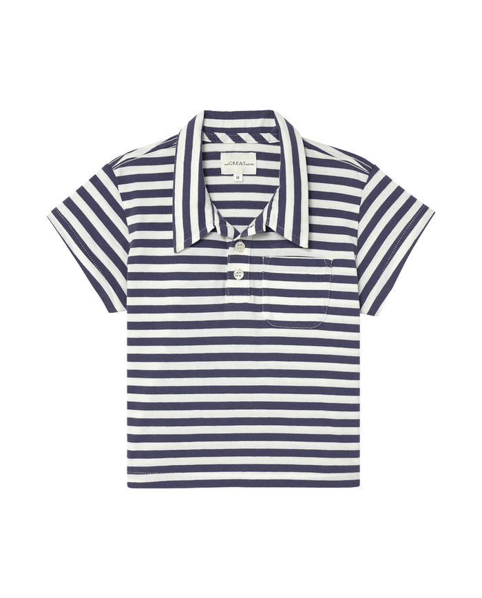 The Little Lacrosse Polo by THE GREAT. SP25 POLO LOUNGE LITTLE in Vintage Blue Stripe offers a stylish touch for lacrosse enthusiasts with its blue and white stripes, short sleeves, three buttons, and chest pocket.
