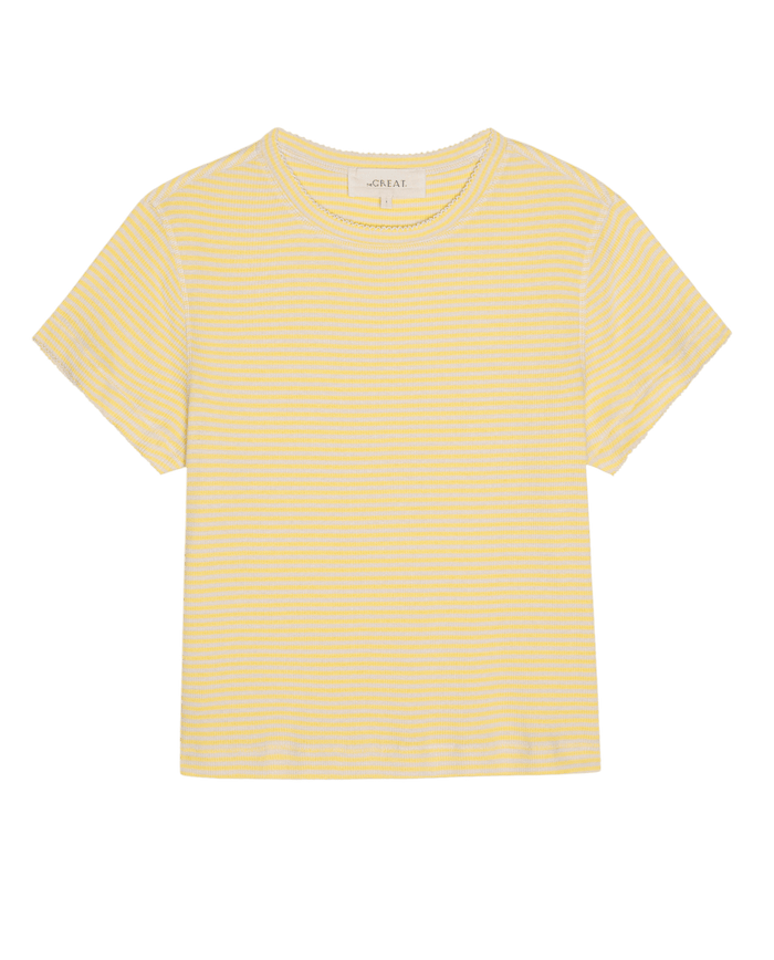 The Little Tee by THE GREAT. SU26, featuring soft yellow and white horizontal stripes, short sleeves, and a crew neck, is shown laid flat on a white background.