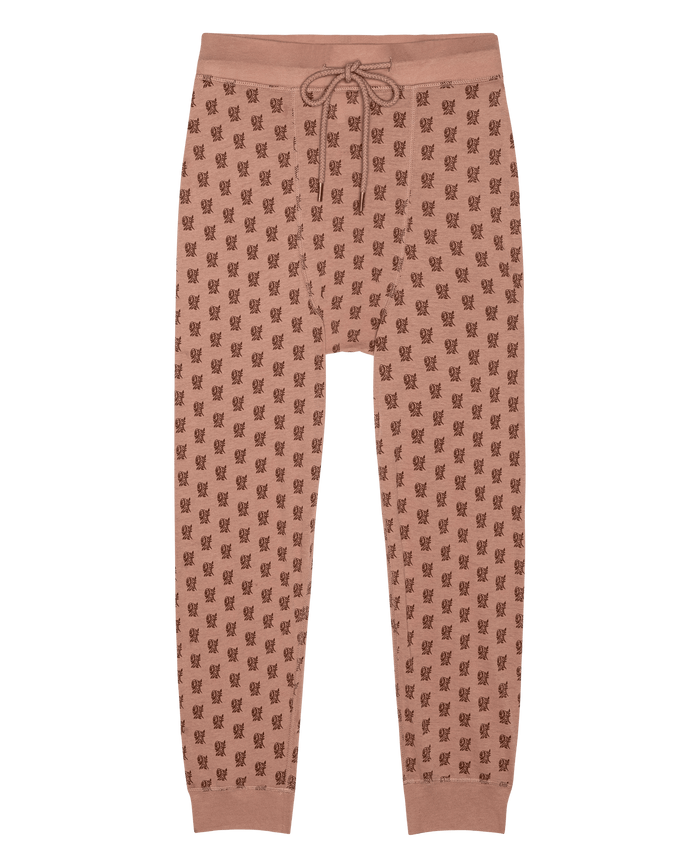 The Long John in Rose Print by THE GREAT. F26 SLEEP features light brown jogger pants with a repeated dark brown rose pattern, a drawstring waist, and cuffed ankles, displayed flat against a white background.