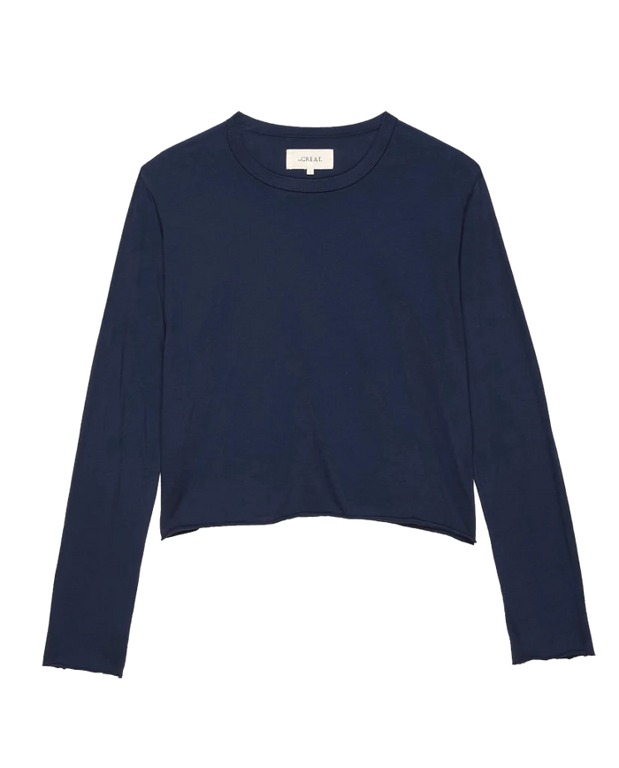 A handcrafted Los Angeles, THE GREAT. FALL 23 KNITS True Navy Long Sleeve Crop Tee featuring a round neckline and a slightly frayed hem.