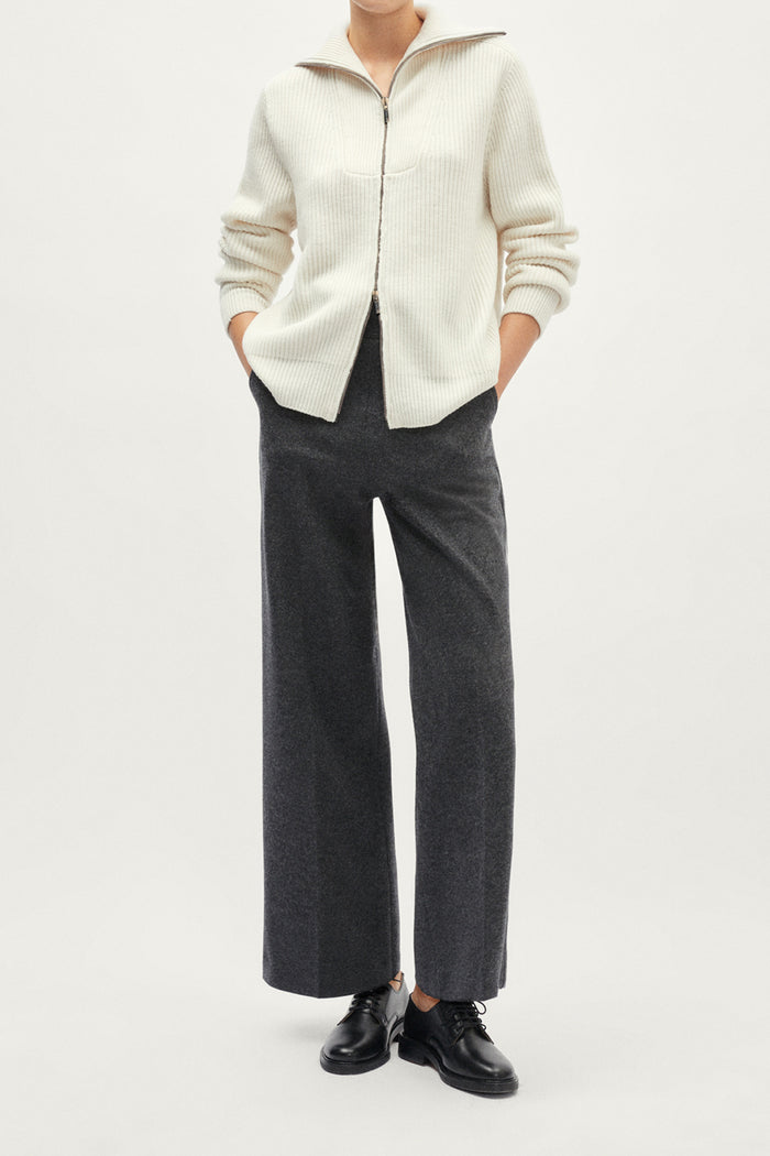 White ribbed sweater with a zipper on a light gray background