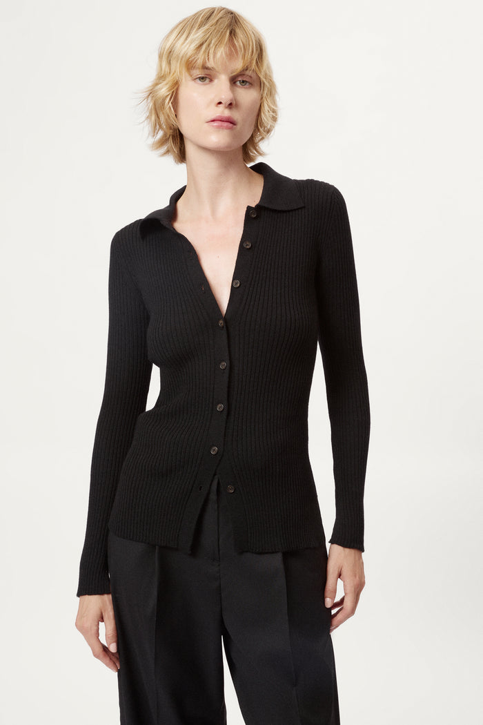 Woman wearing a black ribbed merino shirt  on a white background