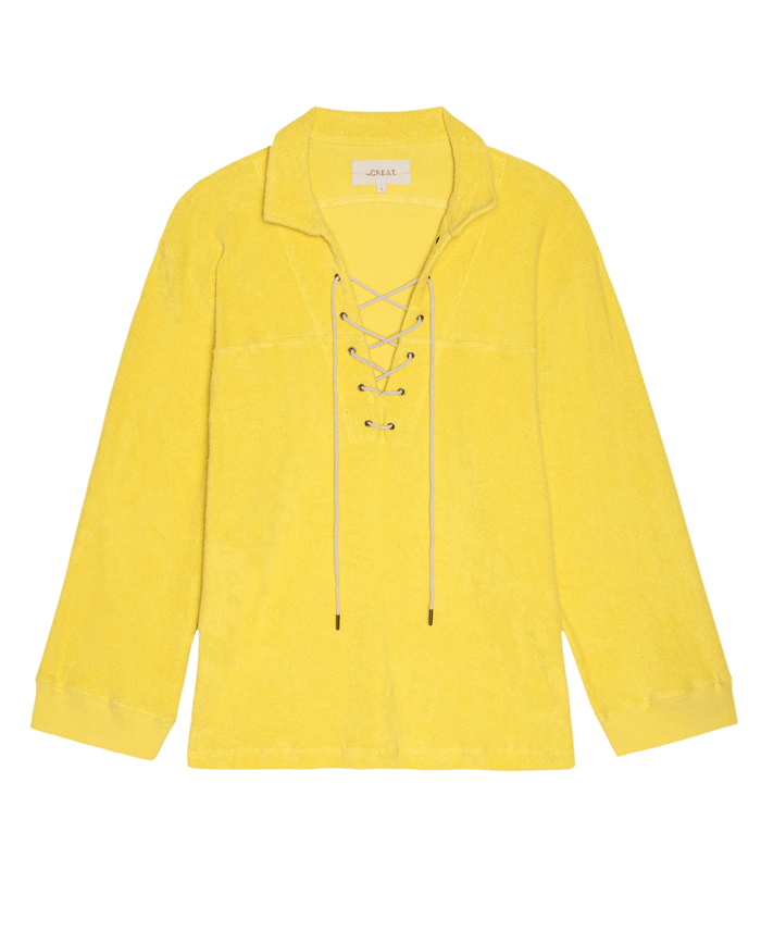 The Micro Terry Lace Up Tunic in Margarita by THE GREAT. SU26, a yellow long-sleeve micro terry collared top with lace-up front detail, is laid flat on a white background.
