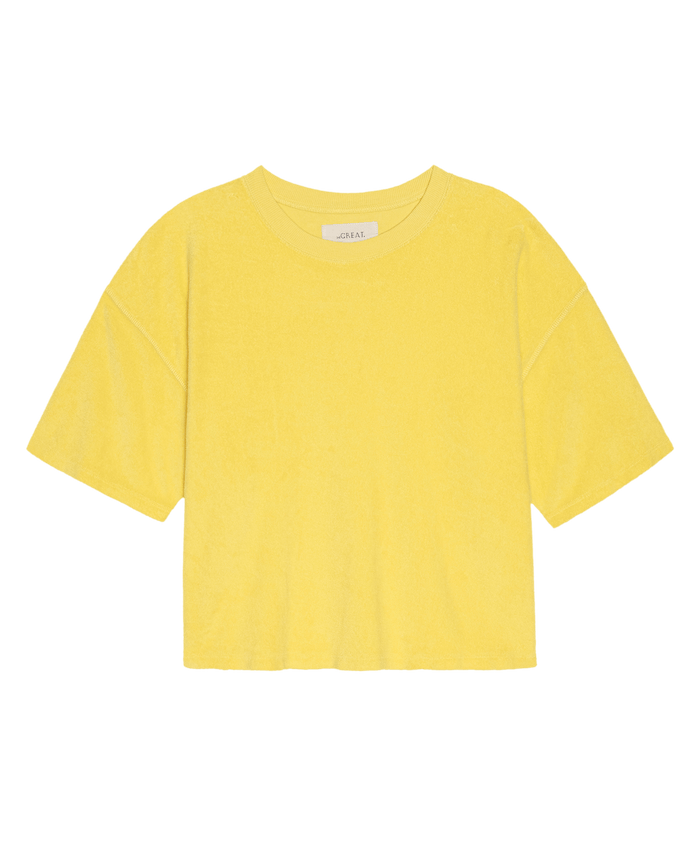 THE GREAT. SU26’s The Micro Terry Track Crew in Margarita, a soft yellow short-sleeve tee crafted from micro terry fabric, is shown on a white background—ideal for track crews or casual wear.