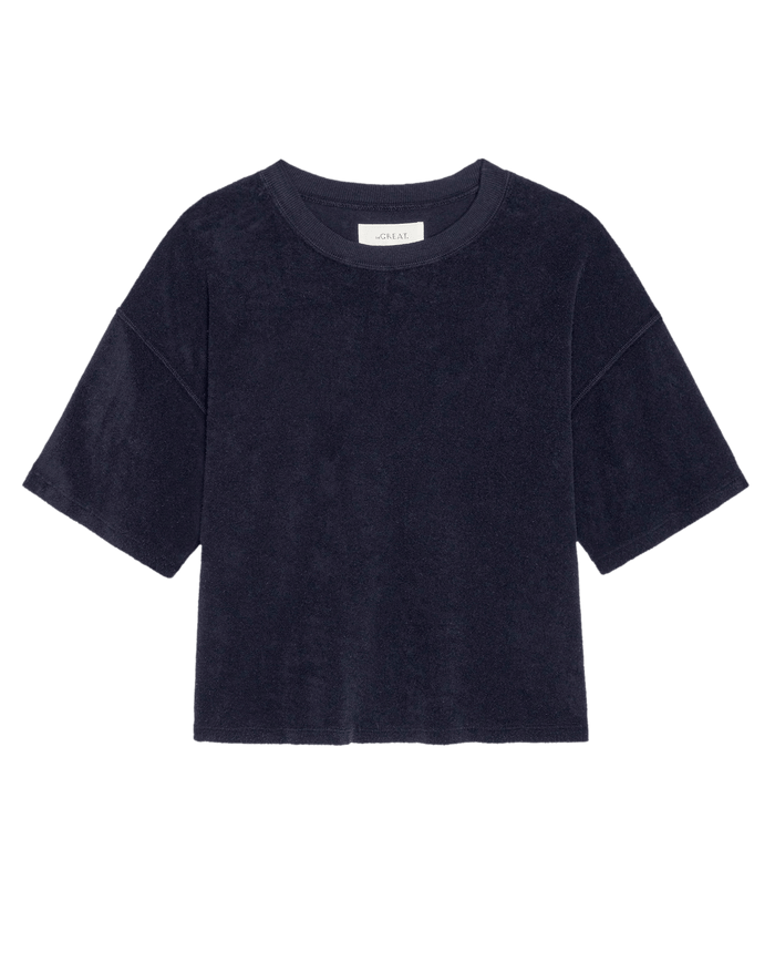 The Micro Terry Track Crew by THE GREAT. SU26 in navy, a short-sleeve micro terry T-shirt with a crew neckline, is displayed flat against a white background.
