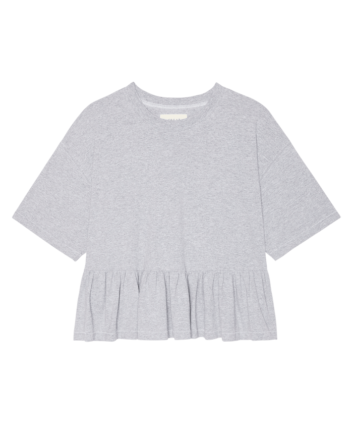 The Oversized Ruffle Peplum Tee in heather grey by THE GREAT. SP26 DANCER BODIES features short sleeves, heavyweight jersey, a round neckline, and a gathered peplum hem. Displayed on a plain white background.