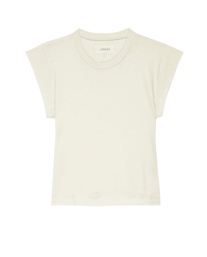 The Peak Shoulder Tee in Washed White by THE GREAT. FALL 22 KNITS is elegantly displayed against a white background, featuring short sleeves and a crew neck, making it perfect for pairing with high-waisted denim.