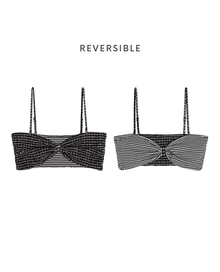 THE GREAT. SP26 SWIM's The Reversible Cinched Bandeau in Black & Cream Check features two reversible bandeau bikini tops with adjustable straps—one solid black, the other black-and-white check—shown on a plain white background.