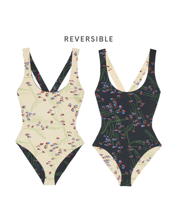 Two Reversible Cross-Back One Piece swimsuits by THE GREAT. SP26 SWIM are shown in the Windblown Bouquet print, each featuring a scoop neckline and reversible design: cream floral on one side, black floral on the other.