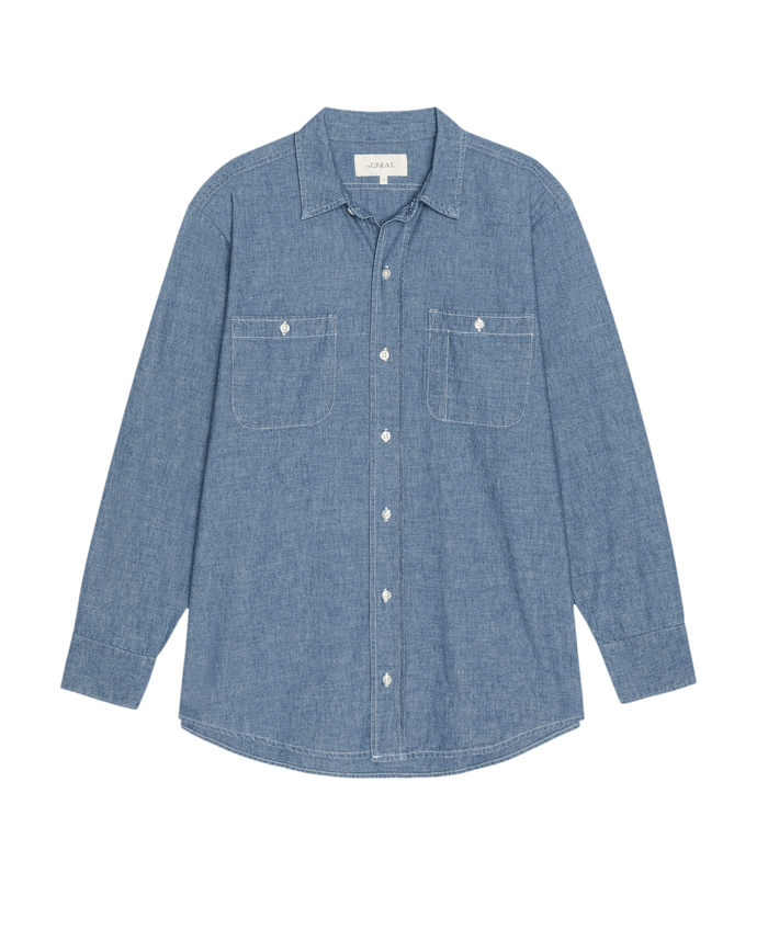 The GREAT. SU26 The Road Shirt in Shoreline Wash, a button-up chambray shirt with long sleeves and two chest pockets, shown flat on a white background.