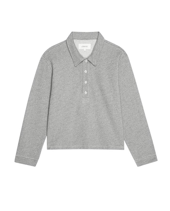 The Rugby Sweatshirt in Varsity Grey by THE GREAT. SP25 POLO LOUNGE is laid out flat, a gray long-sleeve with a collar and four buttons, resembling a classic rugby sweatshirt.