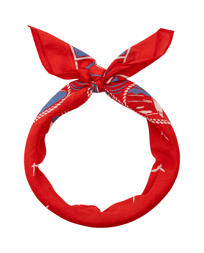 The Sailboat Bandana in red by THE GREAT. SU26, featuring white and blue patterns, is tied in a simple knot against a plain white background.