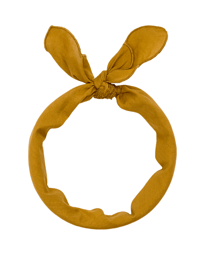 The Scalloped Bandana in Clay by THE GREAT. SU26 features a chic knotted bow and scalloped edges, styled like a fashionable hairband, shown on a white background.