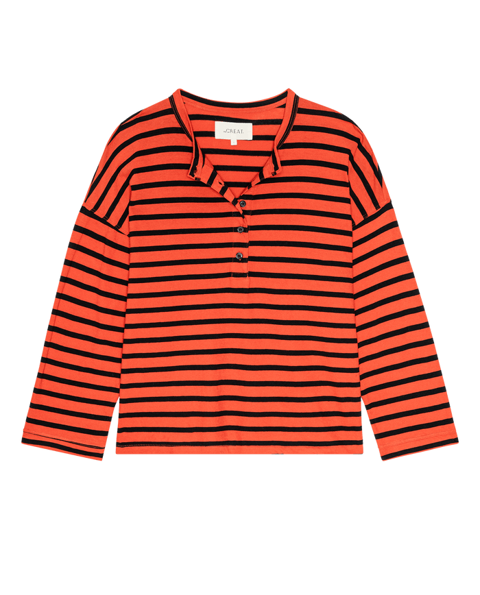 The Shrunken Henley in Hot Red Naval Stripe by THE GREAT. F26 D1 is a long-sleeved, fitted henley shirt featuring horizontal black and red-orange stripes and a partial button placket at the collar, shown laid flat on a white background.