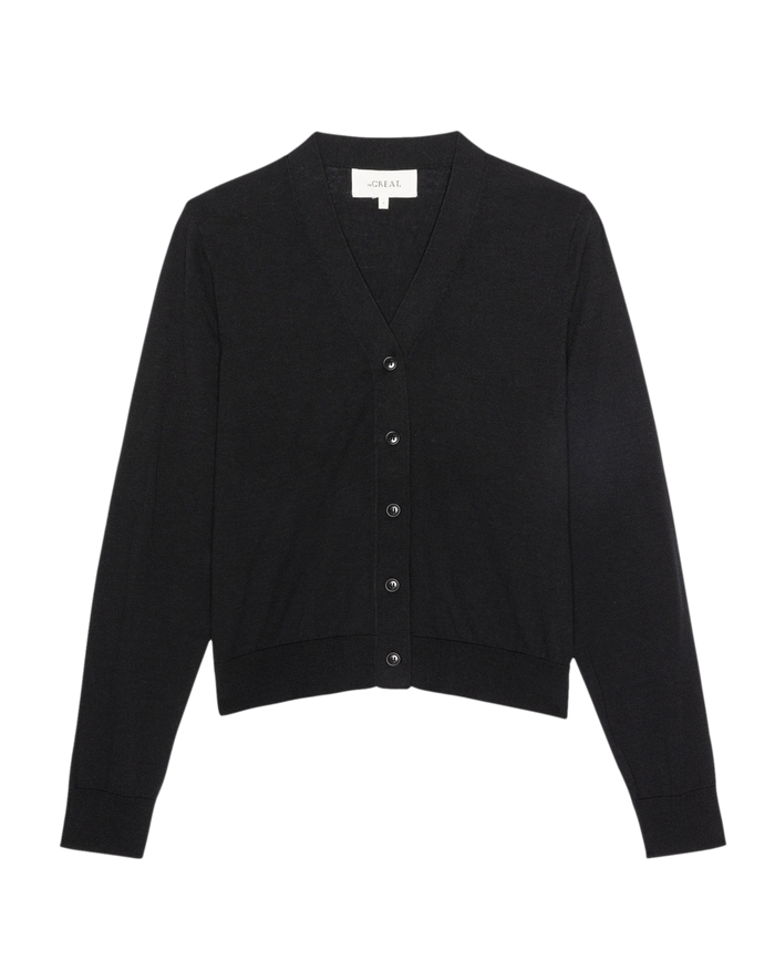The Shrunken V Neck Cardigan by THE GREAT. SP26 D1, in black, with long sleeves and a button-up front, is laid flat on a white background.